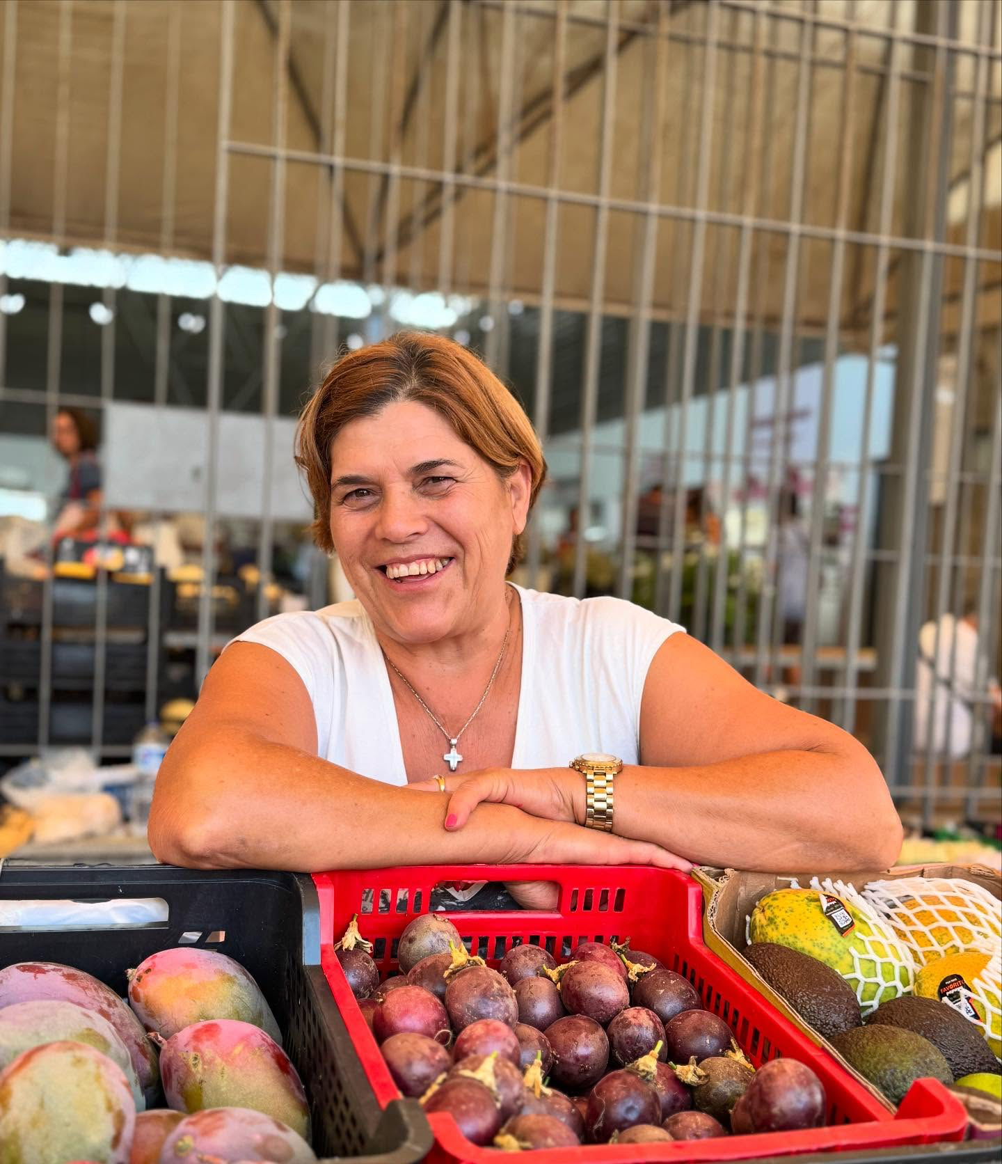 Júlia atrás da banca com fruta fresca